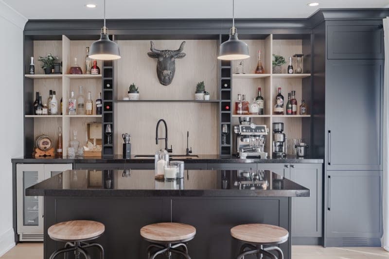 Basement bar area with custom cabinetry and bar seating