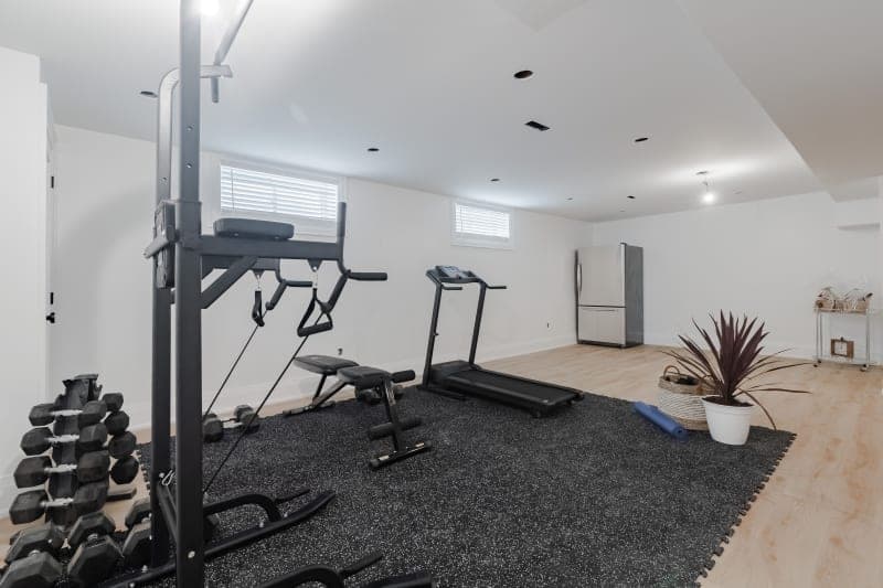 Home gym conversion with rubber flooring and wall mirrors